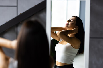 Beautiful young woman looking at herself in ther mirror indoors