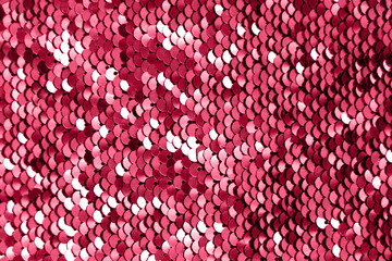 Pieces of cloth with magenta sequins. Glitter background. Sequin texture. Color of 2023.