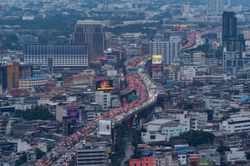 Fototapeta na wymiar Aerial view of busy cars with traffic jam in the rush hour on highway road street on bridge in Bangkok Downtown, urban city in Asia, Thailand at sunset. Intersection junction. Toll gate in Rama 9
