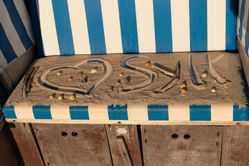  I love Sylt Schriftzug im Sand auf einem Strandkorb gemalt  - obrazy, fototapety, plakaty