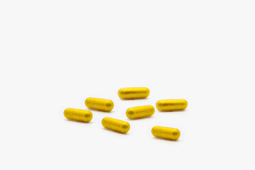 Gold capsule supplements on white background