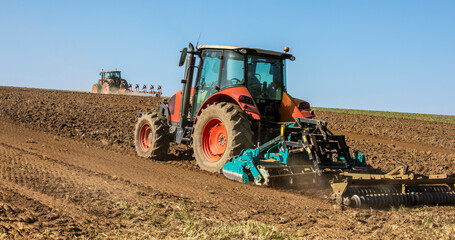 Tracteur labourant les champs au printemps dans la campagne.