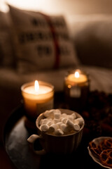 New Year 2022-2023. New Year's decoration. Christmas tree. Candle near the Christmas tree for the holiday. Marshmallow and hot chocolate in a cup.