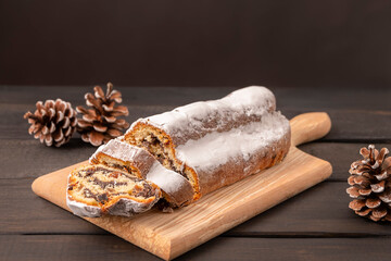 Traditional Christmas cake Stollen on dark wooden background with copy space