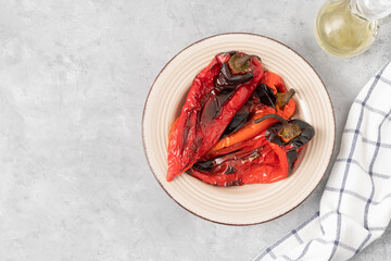 Top view of plate with roasted red peppers on neutral grey background with copy space. Balkan food