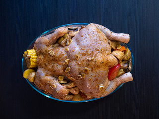 Poultry stuffed with vegetables on a baking dish, the process of cooking baked chicken with vegetables.