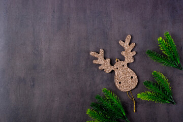 Christmas background with golden deer shaped decoration on gray table. Festive New Year flat lay with copy space