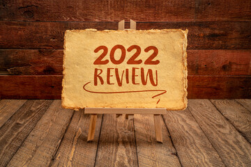 2022 year review - easel sign with antique paper against rustic wood, end of year business concept