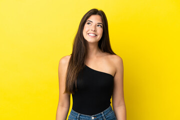Obraz premium Young Brazilian woman isolated on yellow background thinking an idea while looking up