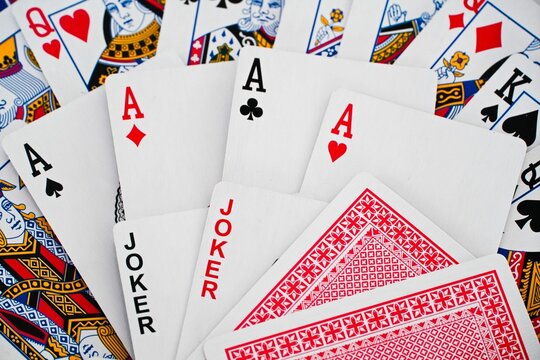 Playing cards background with spread out cards.  Decorative diamond, hearts, spades, clubs, jokers, aces, card mix.
