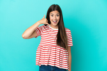 Young Brazilian woman isolated on blue background making phone gesture. Call me back sign