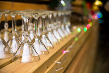 Fototapeta na wymiar clean martini glasses are upside down on the wooden shelf of the bar