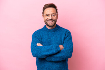 Middle age caucasian man isolated on pink background keeping the arms crossed in frontal position