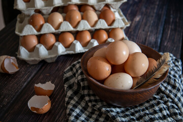 Chicken eggs in a clay plate and trays on the table