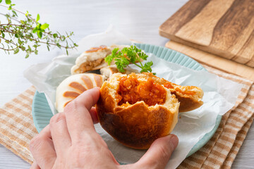 焼けたピザまんを食べる