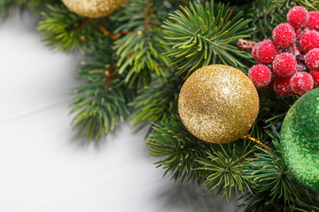 beautiful branches of a Christmas tree with cones and toys on a white wooden background with the inscription Merry Christmas