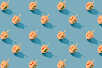 Jewish holiday Hanukkah concept. Wooden dreidel (spinning top) pattern on blue background.