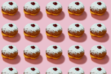 Jewish holiday Hanukkah concept. Pattern with donut sufganiyot on a pink background.