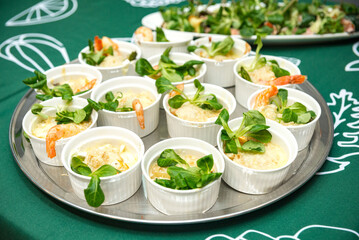 Seafood appetizer in spicy saffron sauce and garnished with corn salad
