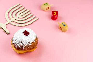Jewish holiday Hanukkah concept. Menorah - traditional candelabrum or hanukkiah, donut sufganiyot and wooden dreidel - spinning top