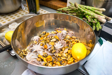 The seafood cocktail is defrosted in a metal bowl. Bunch of Mussels, small octopuses.
