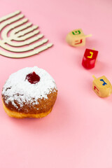 Jewish holiday Hanukkah concept. Menorah - traditional candelabrum or hanukkiah, donut sufganiyot and wooden dreidel - spinning top
