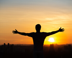 Fototapeta na wymiar Man with open arms to the sunset in Sao Paulo, Brazil