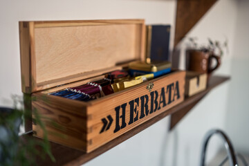 Taking tea out of a wooden box with the word "herbata" (tea i Polish) on the side. Tea stored in bags, placed in a wooden box.