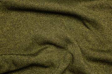 Texture of knitted fabric in green color. Light khaki back.