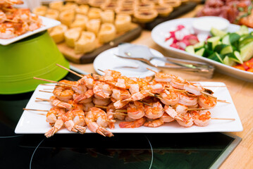 Shrimp kebabs on skewers on the festive table. Appetizer set on the catering table