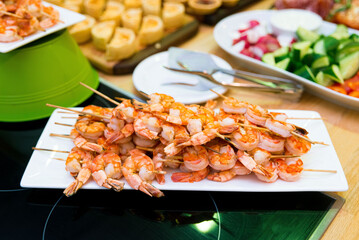 Shrimp kebabs on skewers on the festive table. Appetizer set on the catering table