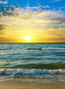 Sun rise over the sea background. Colorful ocean beach. Vertical photo.