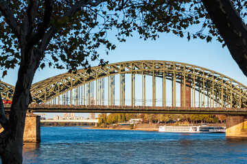 Hohenzollernbrücke in Köln über den Rhain von Bäumen eingerahmt