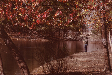 Fototapeta premium Man fishing fall color backwater along the Iowa River near the Coralville Lake, in Johnson county, IA, USA