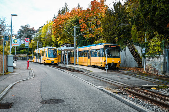 Stuttgart, Germany: October 16, 2022: Two yellow cog railway cars standing at a station during autumn.
