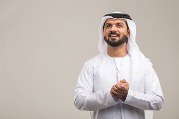 Handsome arab man wearing traditional emirate clothing portrait in studio - Middle eastern...