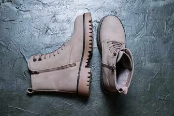 Gray women's winter boots with laces on a dark background. Concept of modern female fashion