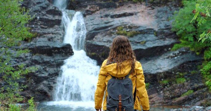 Hiking, freedom and waterfall with a happy woman in celebration of success and life outdoor in nature. Wow, travel and free with a female hiker celebrating a fun adventure experience or enjoy Ireland