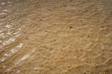 sandy bottom of the red sea at low tide with ripples from the waves