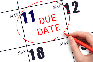 Hand writing text DUE DATE on calendar date May 11 and circling it. Payment due date