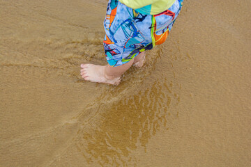 Fototapeta na wymiar feet of a child in the waters of the sea, playing with the family and having fun
