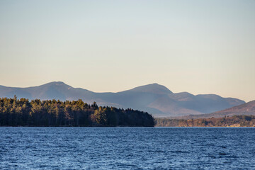 Mountain peaks in the distance behind a lake in the fall
