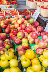 Strawberries and multi variety of apples at a farmer's market.