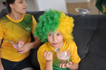 mãe e filha assistindo jogo do brasil copa do mundo pela tv em casa cores lindas 