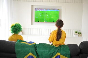 mãe e filha assistindo jogo do brasil copa do mundo pela tv em casa cores lindas  © Alexandre