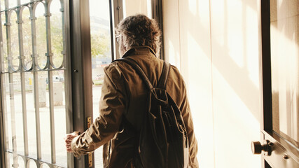 Middle aged man leaving home with luggage