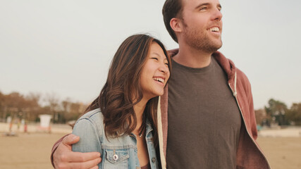 Couple in love hugging each other walking along the beach