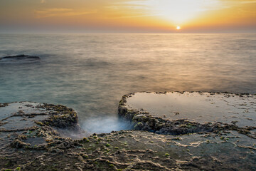 Landscape, sunset in the landscape of the Mediterranean Sea, Israel. Long exposure of waves, dramatic, detailed sky, algae, rocks