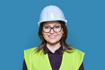 Female industrial construction worker in hardhat vest on blue background
