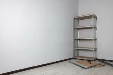 Office room with white walls and metal storage shelf. Space for text